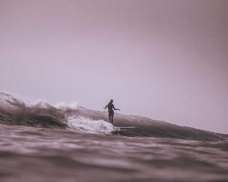 Featured photograph by Haʻa Keaulana featuring Puamakamae DeSoto sliding on her longboard in Mākaha, Oʻahu, 2021, in the series Aia no i ke kō a ke au - Whichever Way the Current Goes.